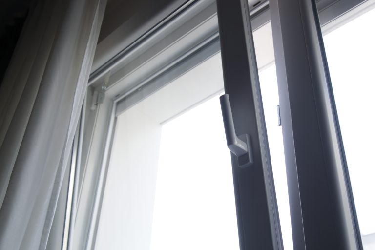 close up shot of vertically open white upvc tilt and turn window